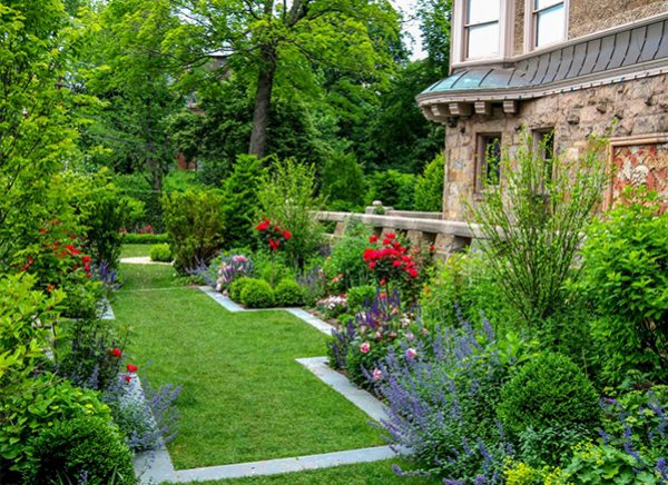 The combination of blue stone edging set in crisp right angles and carefully manicured flower borders