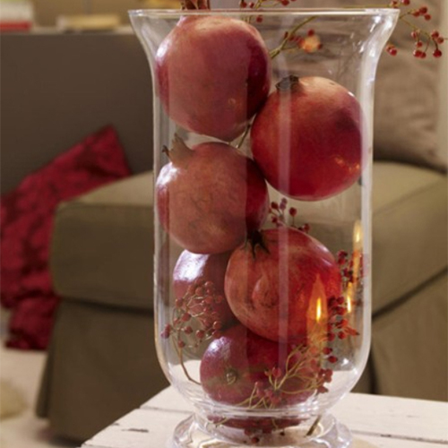 Pile pomegranates between berries branches